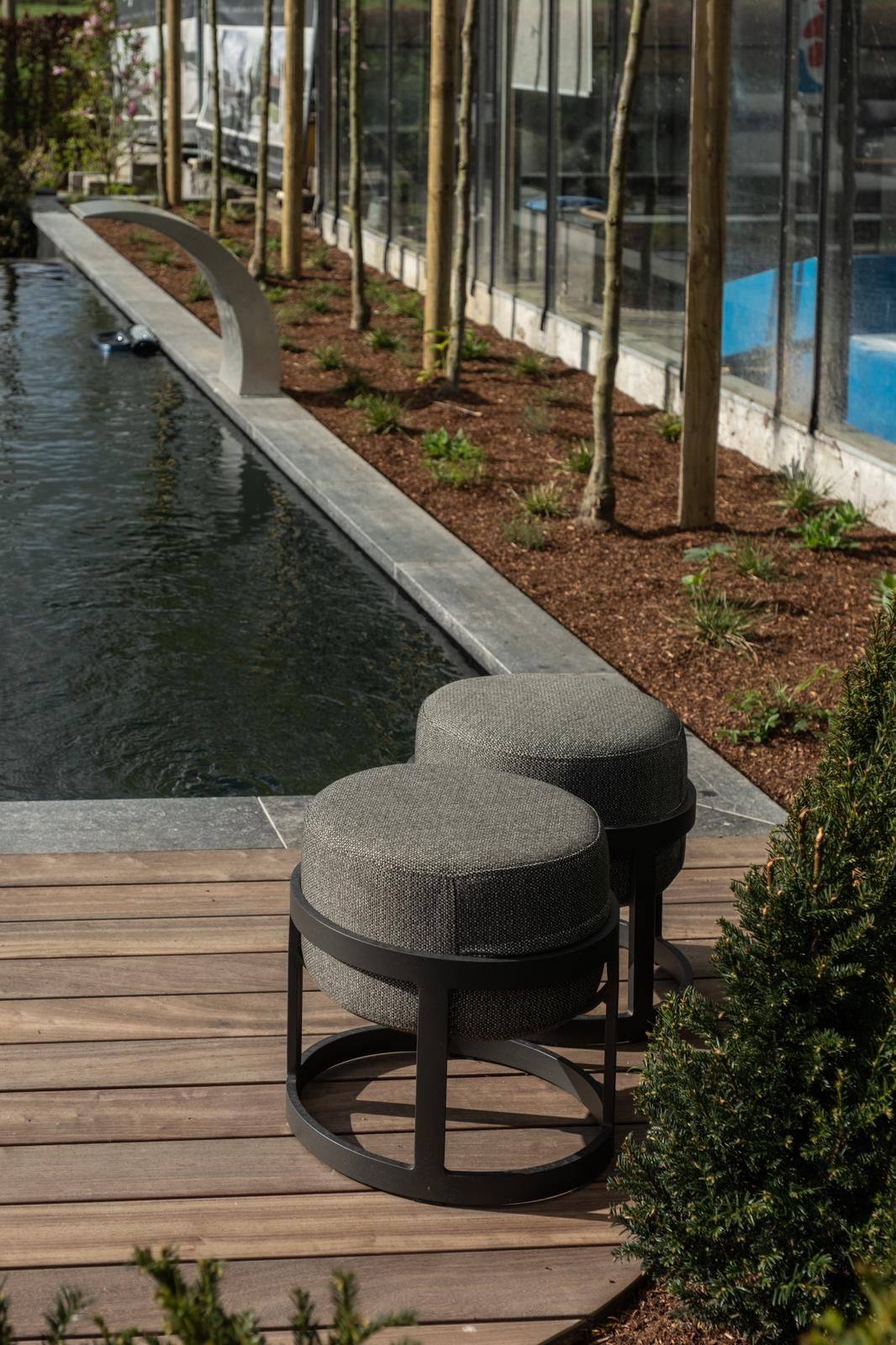 Hardhouten terras langs ecologische vijver Hardhouten terras met grijze poefjes langs een lange ecologische vijver