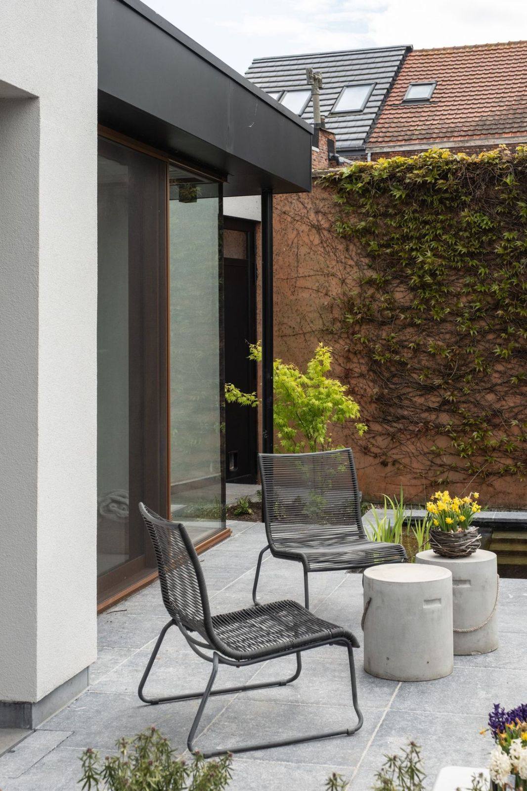 Totaalrenovatie stadstuin met natuursteen terras Totaalrenovatie van een stadstuin met natuursteen terras, strakke vijver en lounge stoelen