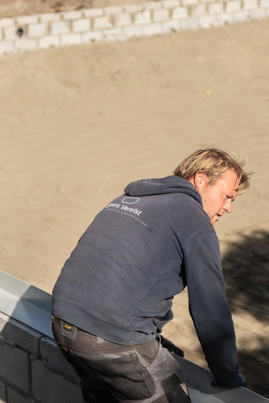 Vakman van Vijvers Verelst aan het werk op een grote werf met betonblokken